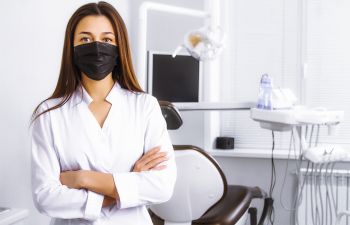 Dentist wearing a protective mask in a treatment room.
